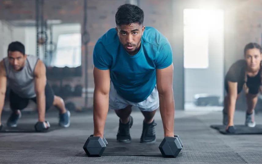 People training with dumbbells on a gym floor